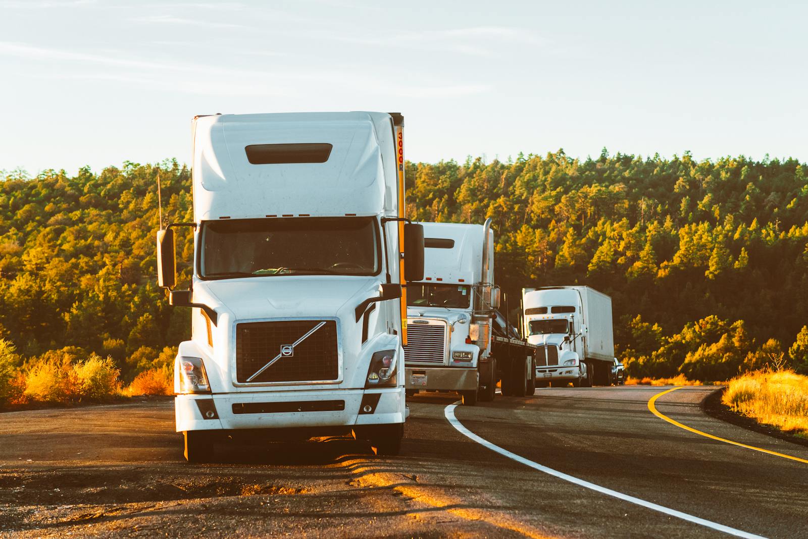 Semi-trucks on highway at sunset — truck accident litigation attorneys